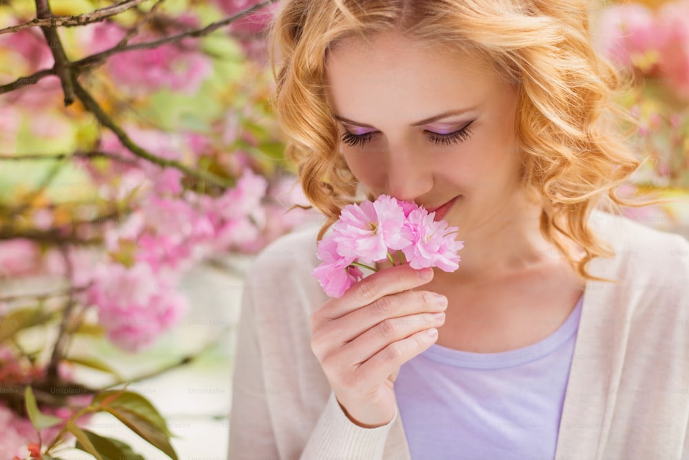 Young beautiful woman in front of a blooming tree