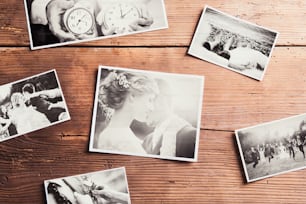 Hochzeitsfotos auf einem Tisch gelegt. Studioaufnahme auf hölzernem Hintergrund.