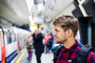 Young handsome man standing on subway platform