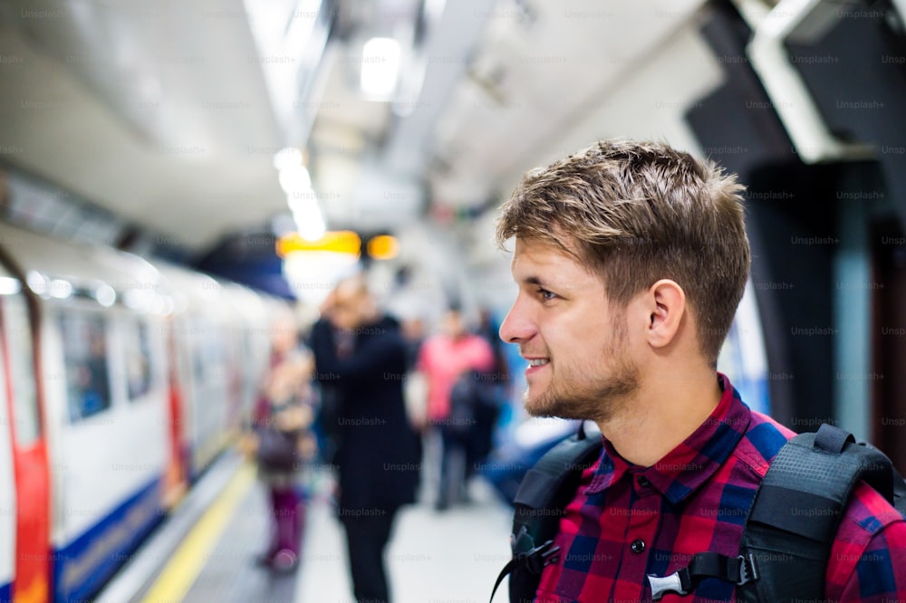 Young handsome man standing on subway platform