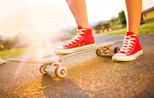 Close up dos pés e skate de uma jovem skatista