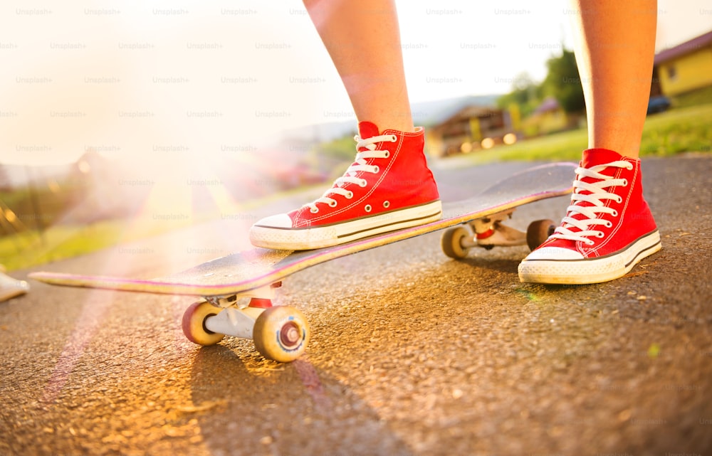 Nahaufnahme der Füße und des Skateboards eines jungen Skatermädchens