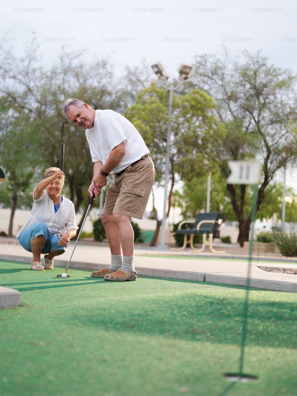 couple de personnes âgées jouant au mini-golf ensemble
