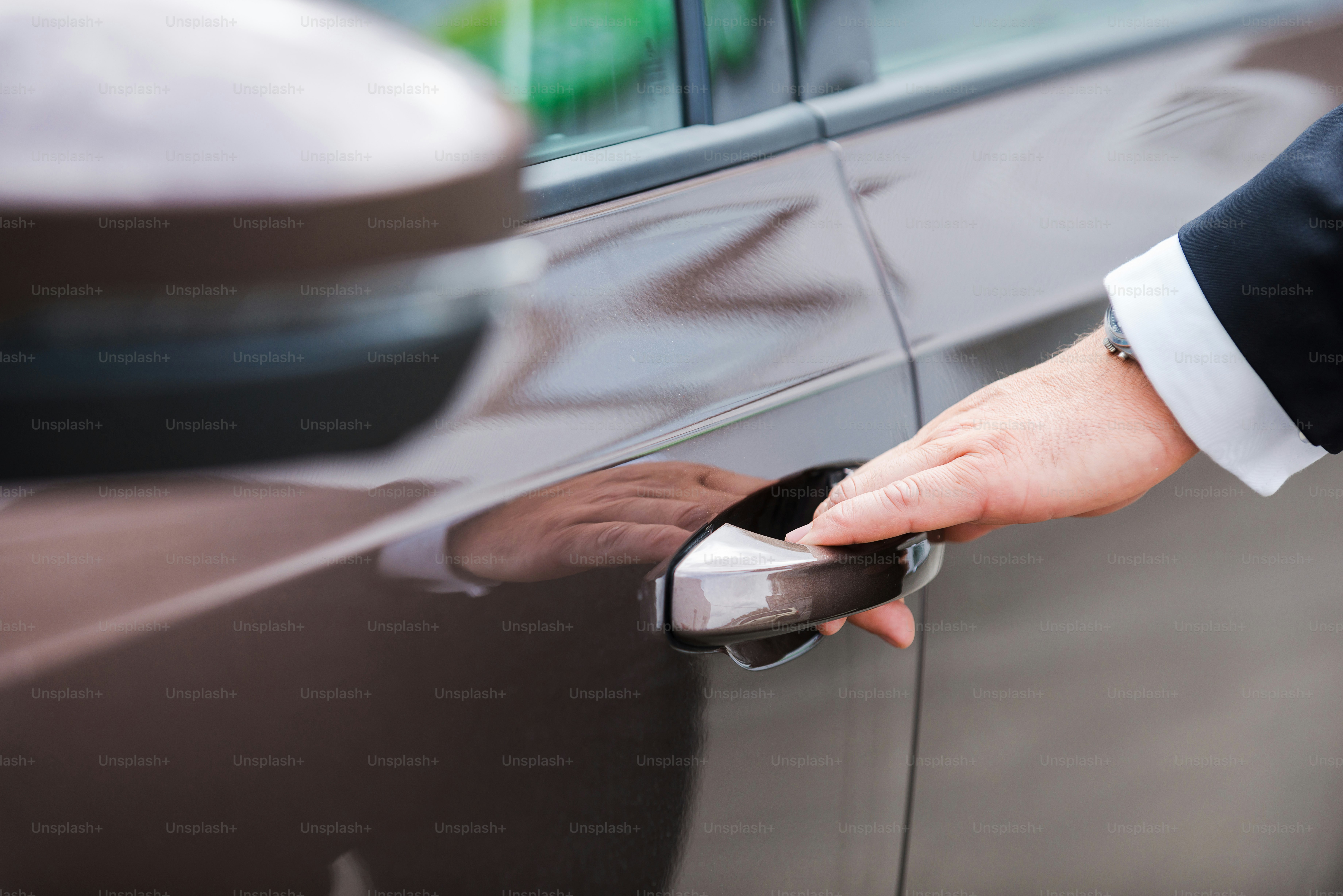Close-up of man in formalwear opening vehicle door