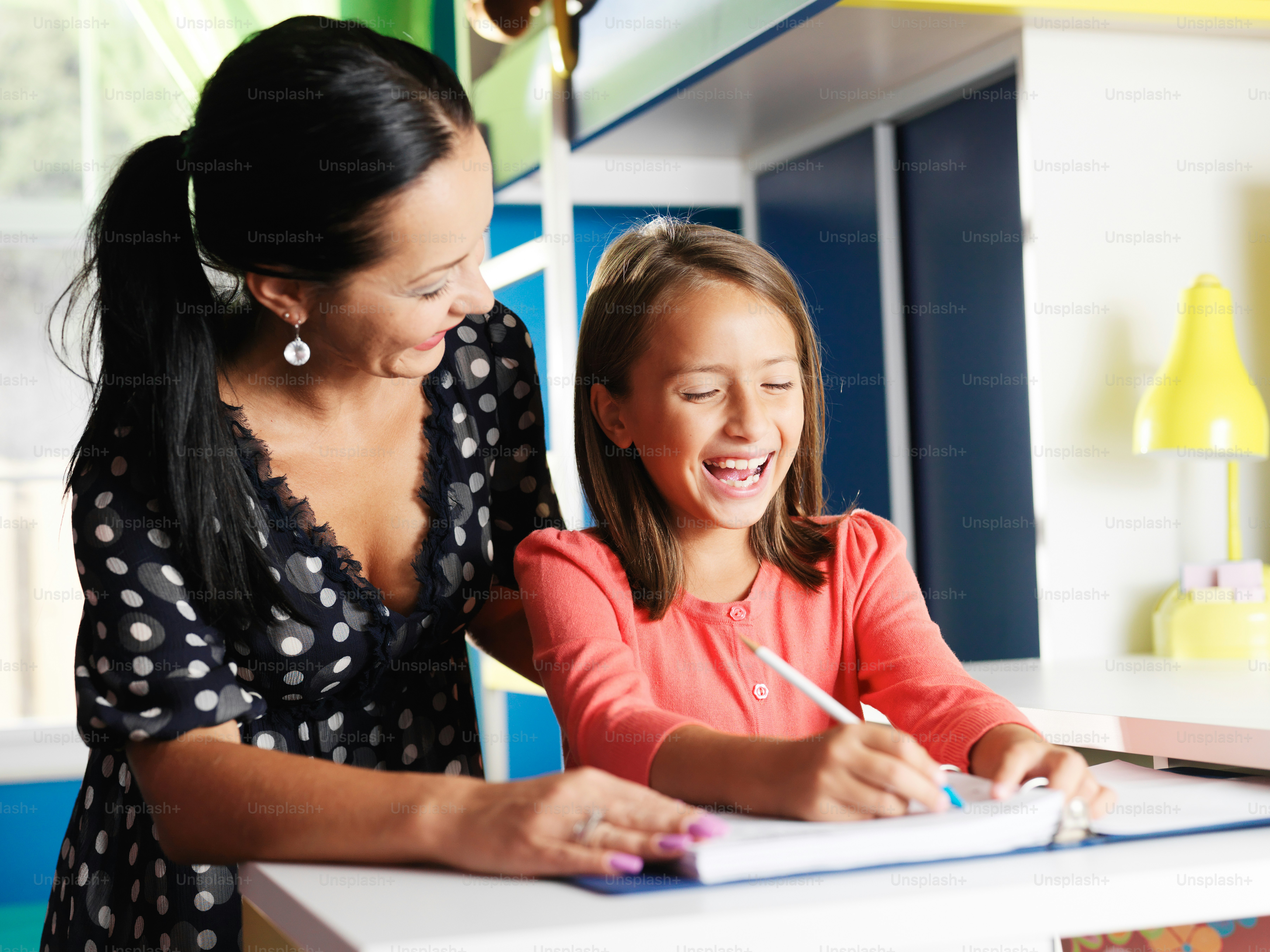 Foto Madre ayudando a su hija feliz con la tarea en su habitación ...