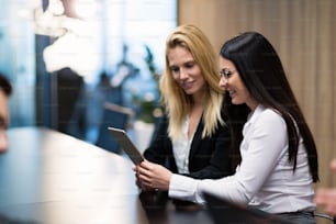 Two attractive businesswomen having discussion in conference room