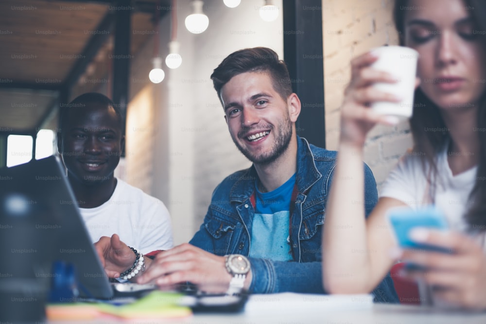 Teamwork concept, brainstorming. Businessman crew working with new startup project in modern loft. Woman holding smartphone hands