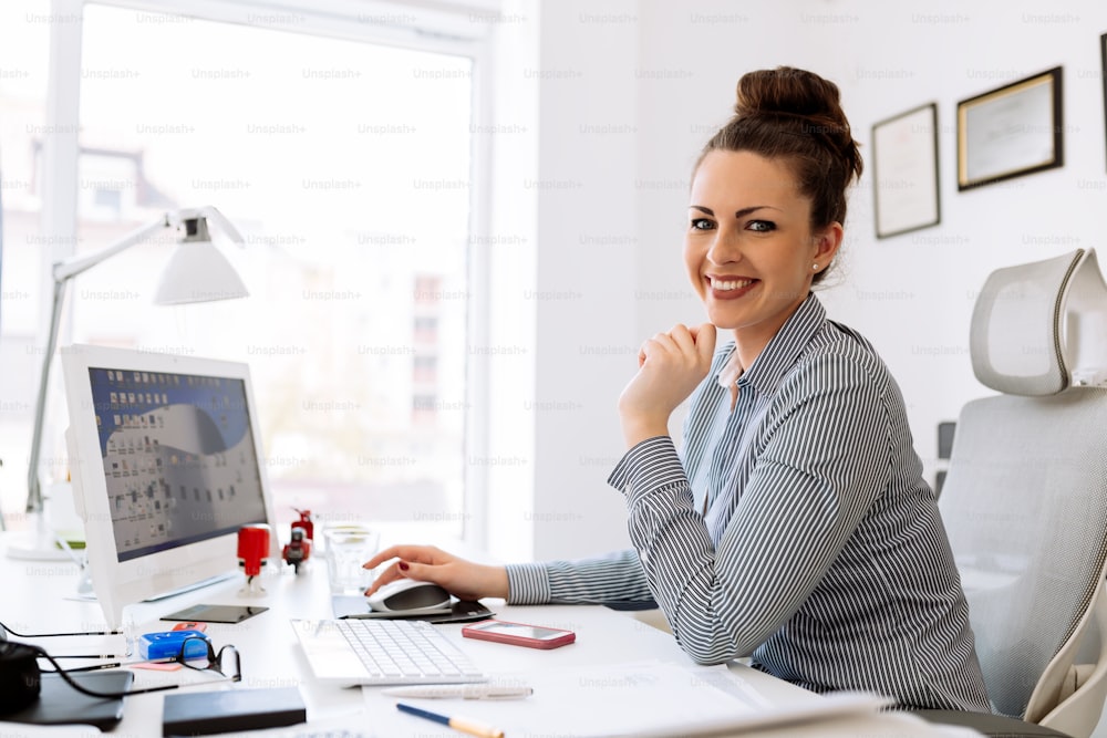 Happy businesswoman working at her desk in office