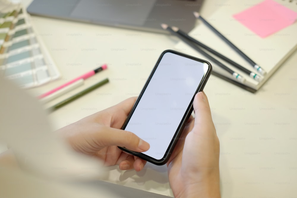 Businessman using mobile phone on white desk in modern office