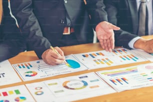 close up hand of marketing manager employee pointing at business document during discussion at meeting room , Notebook on wood table - Business concept