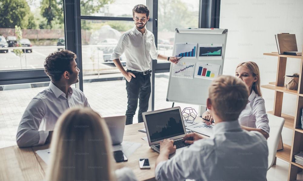 Group of young multiracial people working in modern light office. Businessmen at work during meeting.