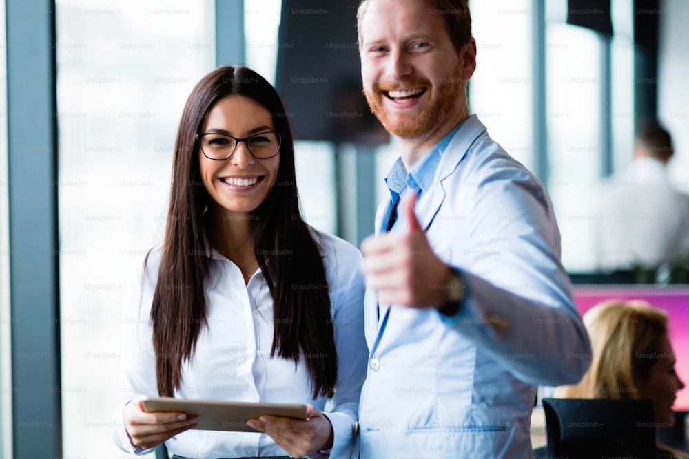 Young attractive business couple using tablet in their company