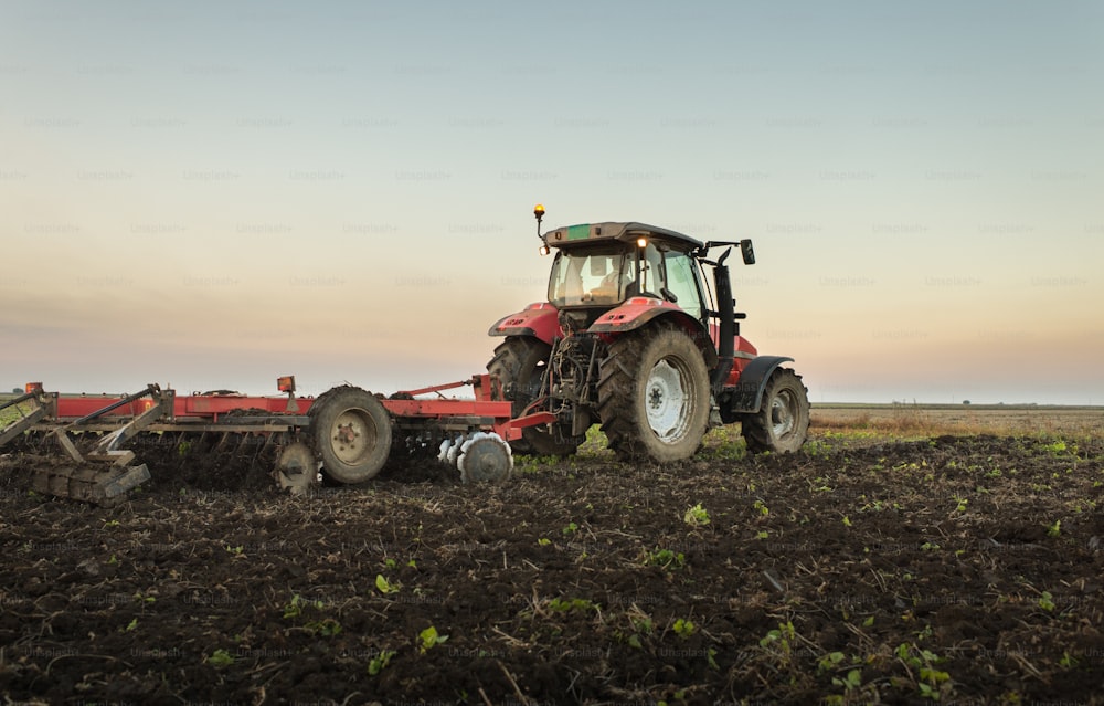 tractor plowing a field at dusk