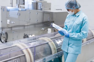 factory worker is checking readings of machine