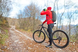 Man mountain biking rest and drink from the bottle before you make the climb