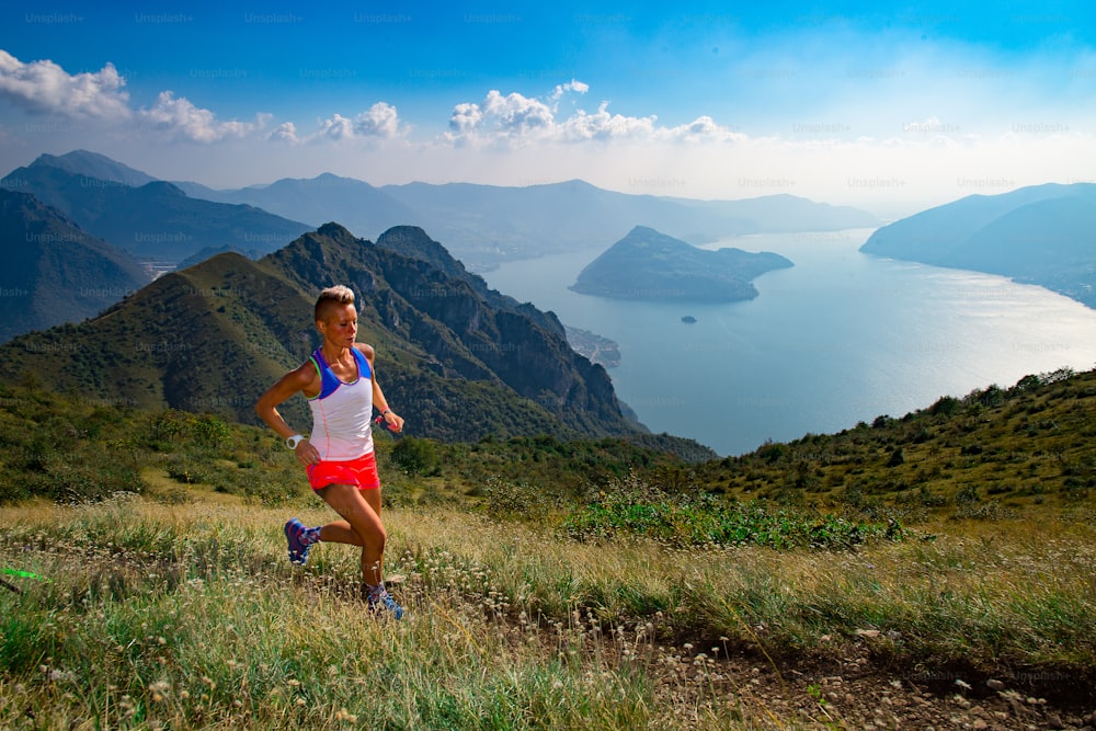 Woman trail running athlete trains in the mountains with fantastic scenery