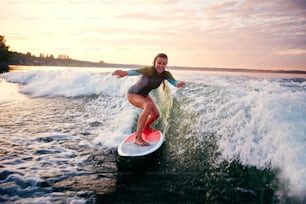 Giovane donna che fa surf al resort estivo
