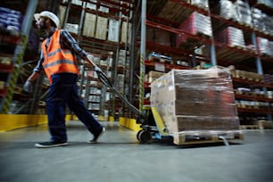 Loader with forklift moving along shelves with goods