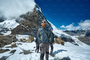 escursionista in cima a un passo con godersi una giornata di sole nelle Alpi. Svizzera, Trekking vicino al monte Cervino.