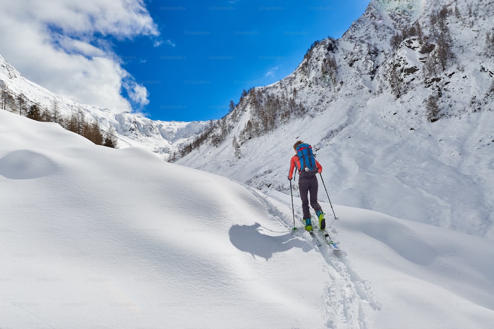 소녀는 알프스에서 혼자 오르막길에서 스키 등산을 한다