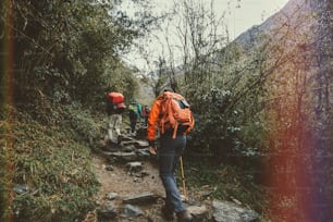 Foto de estilo retrô do grupo de trekkers de montanha na floresta do Himalaia.