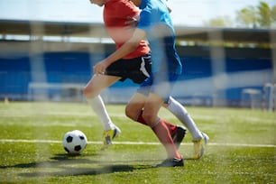 Two running footballers competing on the field