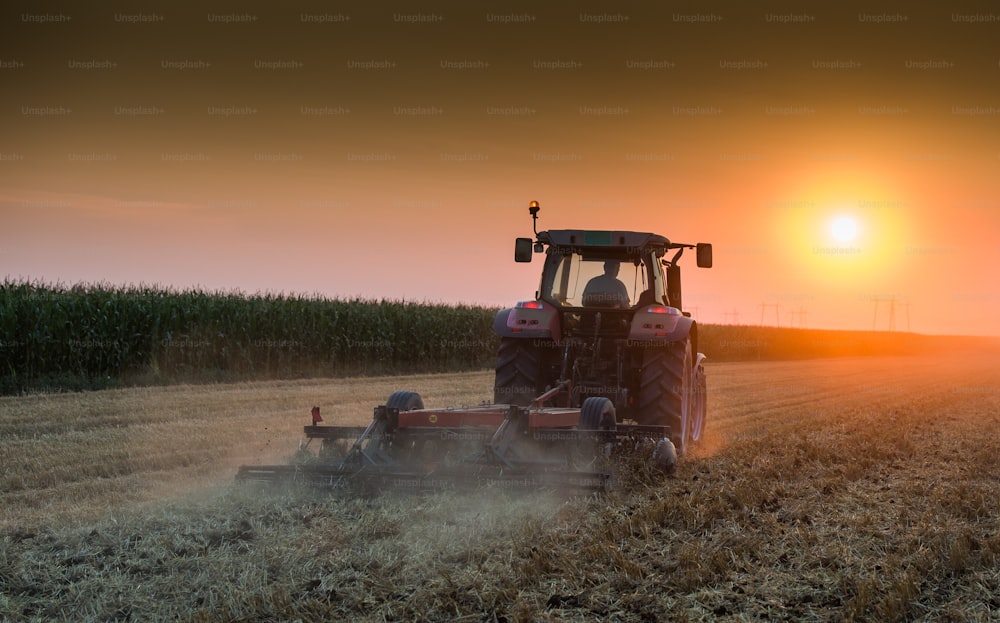tractor plowing field at dusk