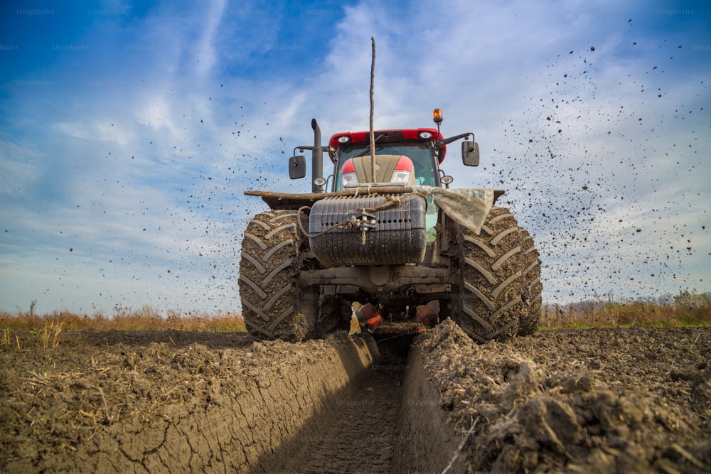 Tractor with double wheeled ditcher digging drainage canal