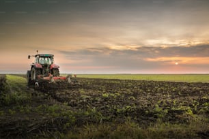 Tractor plowing a field at dusk