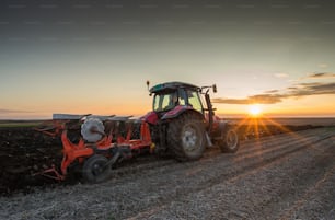 Tractor plowing at sunset