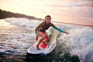 夏のリゾート地で海でサーフボードをしているかわいい女の子