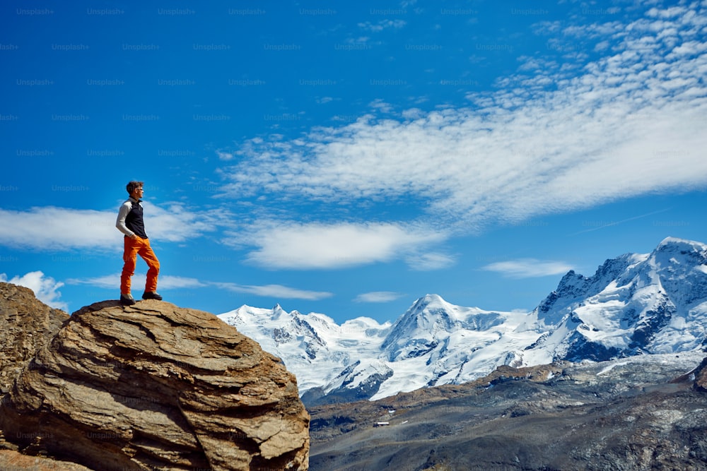 escursionista in cima a un passo con zaino in spalla godersi una giornata di sole nelle Alpi. Svizzera, Trekking vicino al monte Cervino.