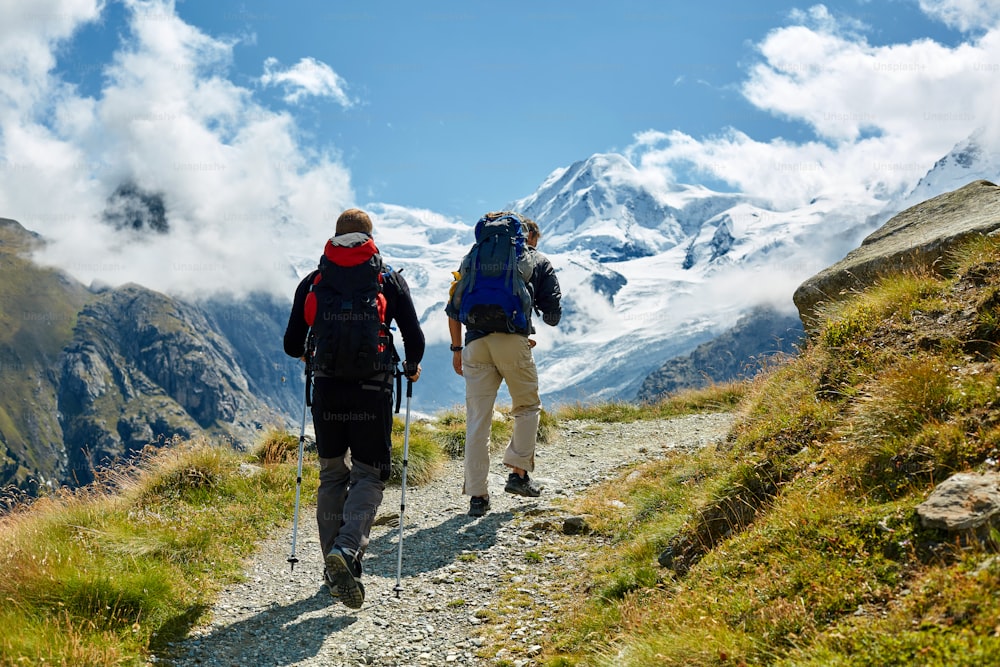 hikers with backpacks on the trail in the Apls mountains. Trek near Matterhorn mount