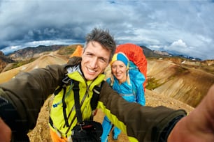 Mann Wanderer Fotograf macht Selfie mit seiner Freundin auf dem Rhyolithgebirge Hintergrund in Island