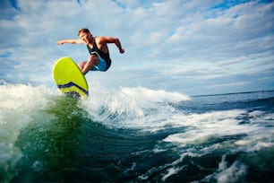 Surfista masculino montando sobre olas en el mar