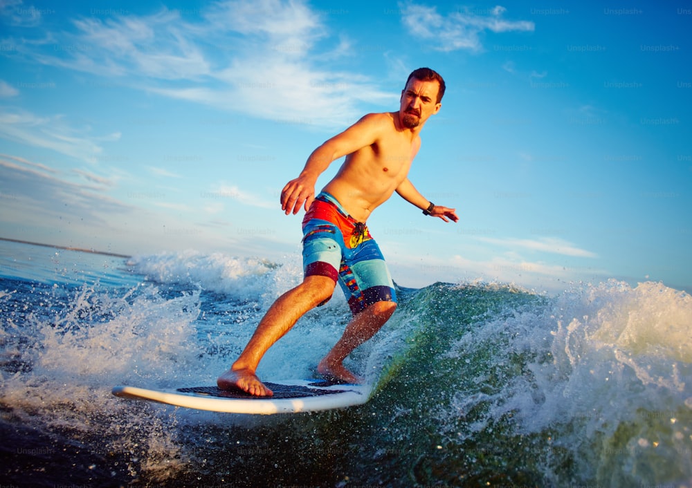 Young man surfboarding in summer