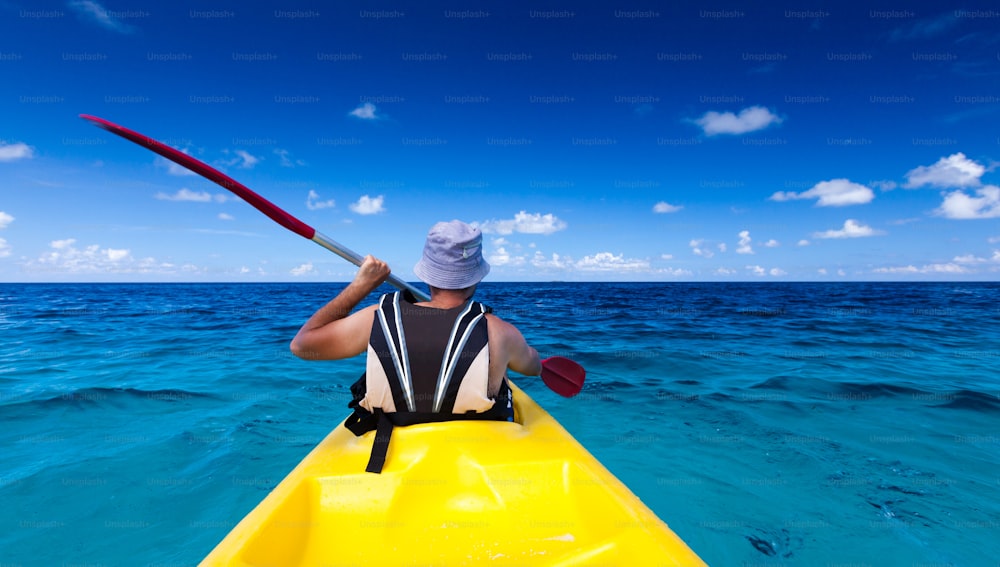 Homme caucasien faisant du kayak en mer aux Maldives