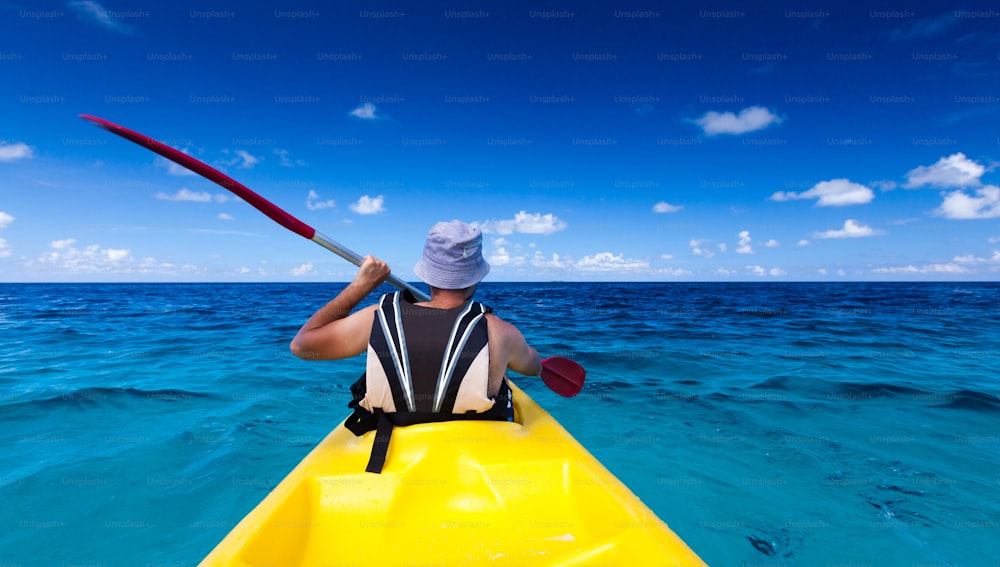 Uomo caucasico in kayak in mare alle Maldive