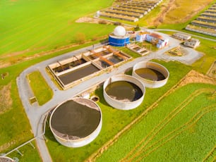 Aerial view to biogas plant from pig farm in green fields. Renewable energy from biomass. Modern agriculture in Czech Republic and European Union.
