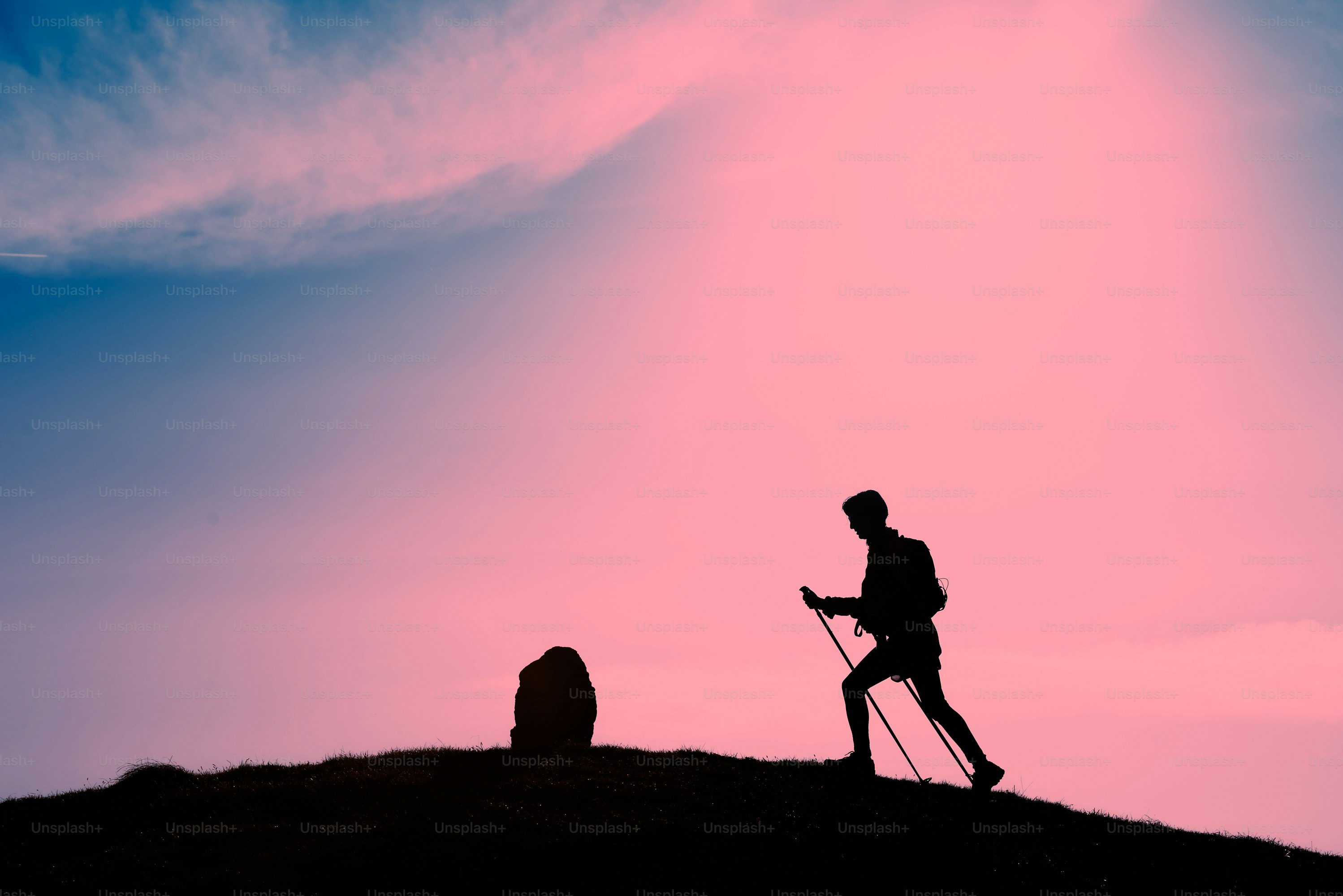 Silhouette of girl that makes trekking in a pink sunset