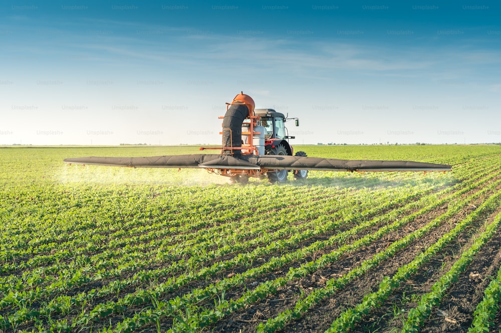tractor spraying pesticides on soy bean