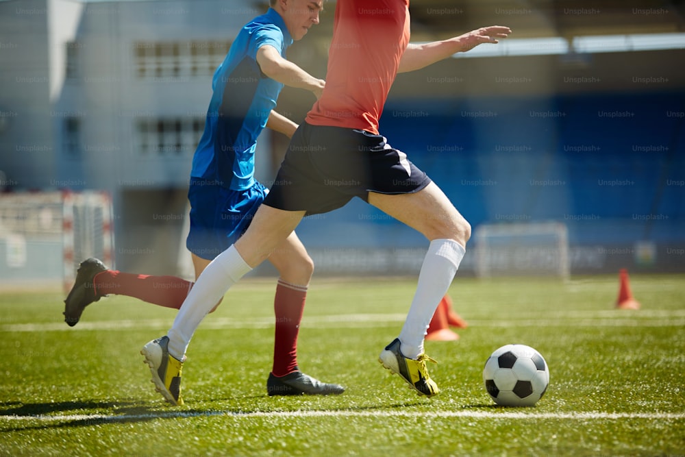 Two footballers running down field after ball