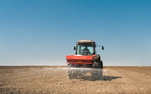 Tractor esparciendo fertilizantes artificiales en el campo