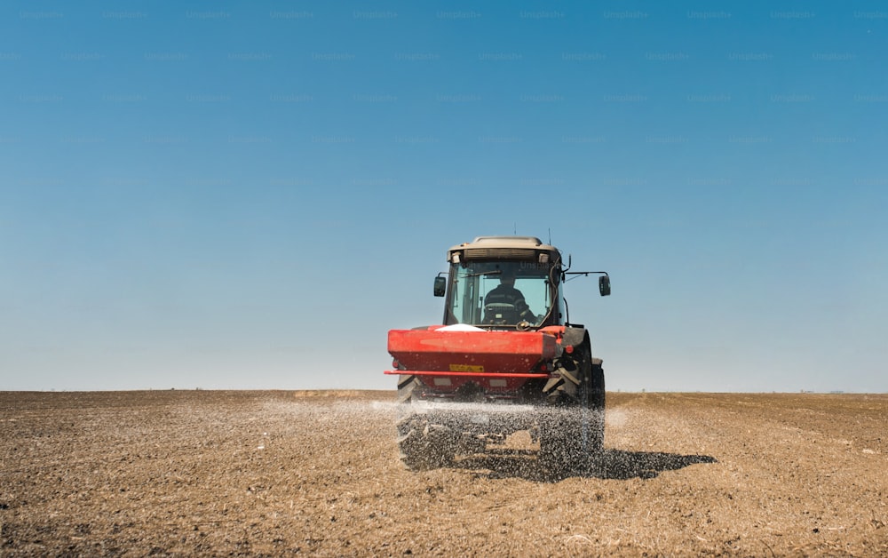 Tractor spreading artificial fertilizers  in field