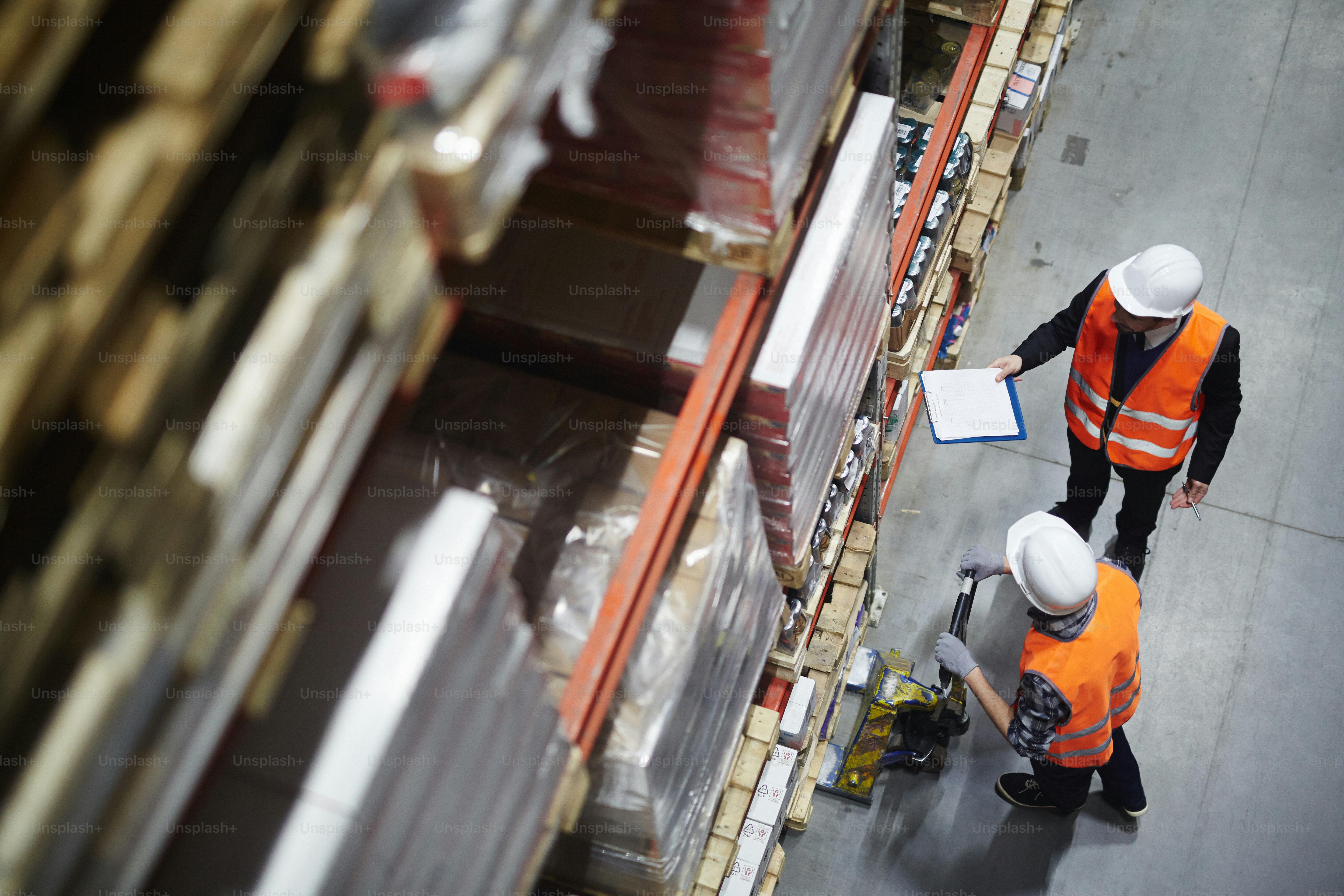 Operations managers reviewing ERP inventory forecasting dashboards in a manufacturing warehouse office