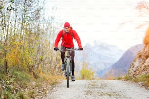 Ciclista de montaña en un camino de tierra solo en otoño
