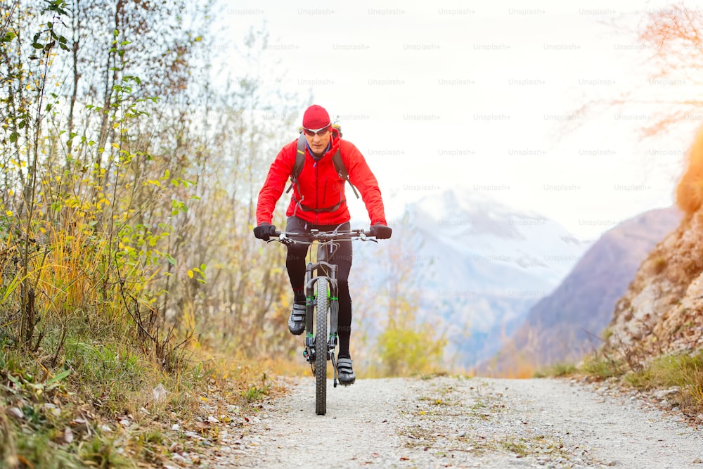 Mountain biker on a dirt road alone in autumn