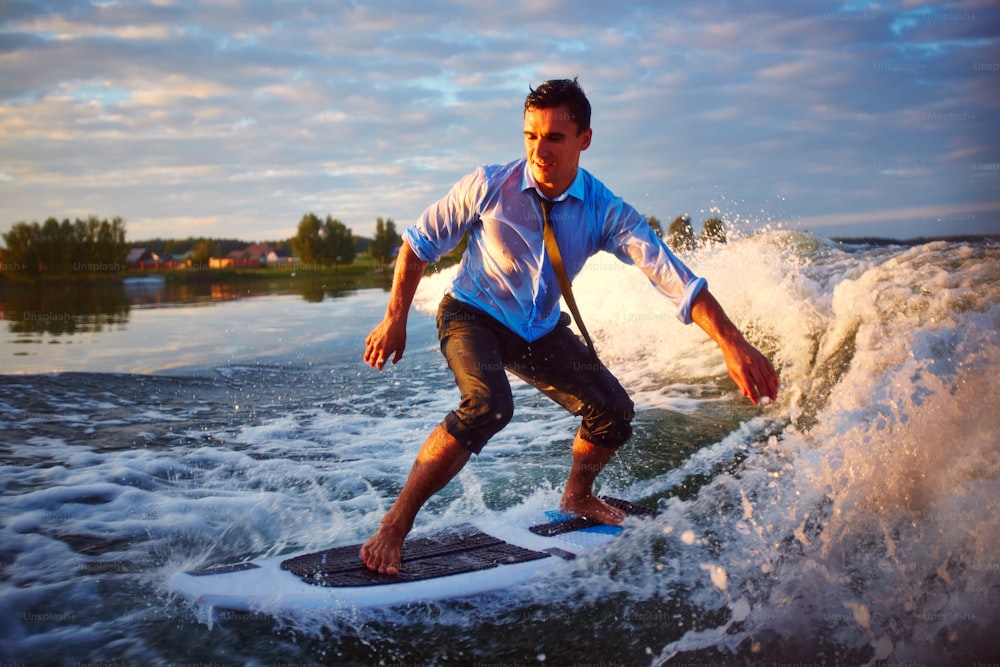 Jovem ativo praticando surfe no resort de verão