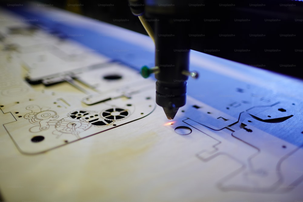 Closeup shot of laser beam cutting complex shapes from wooden part in factory workshop