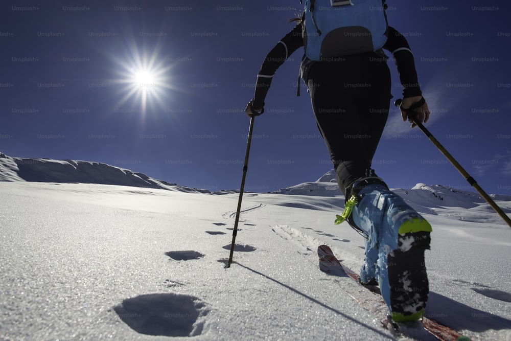 Marcher avec Marcher avec le ski alpinisme avec des peaux de phoque dans les montagnes dans les montagnes vers le soleil